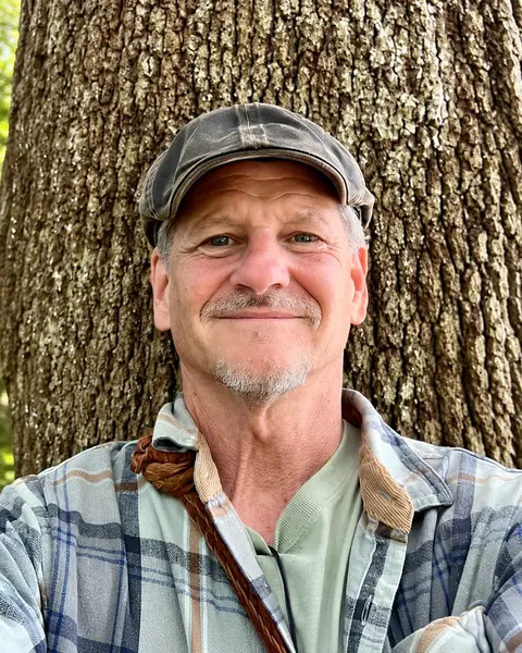 Jon Young vor einem Baum.